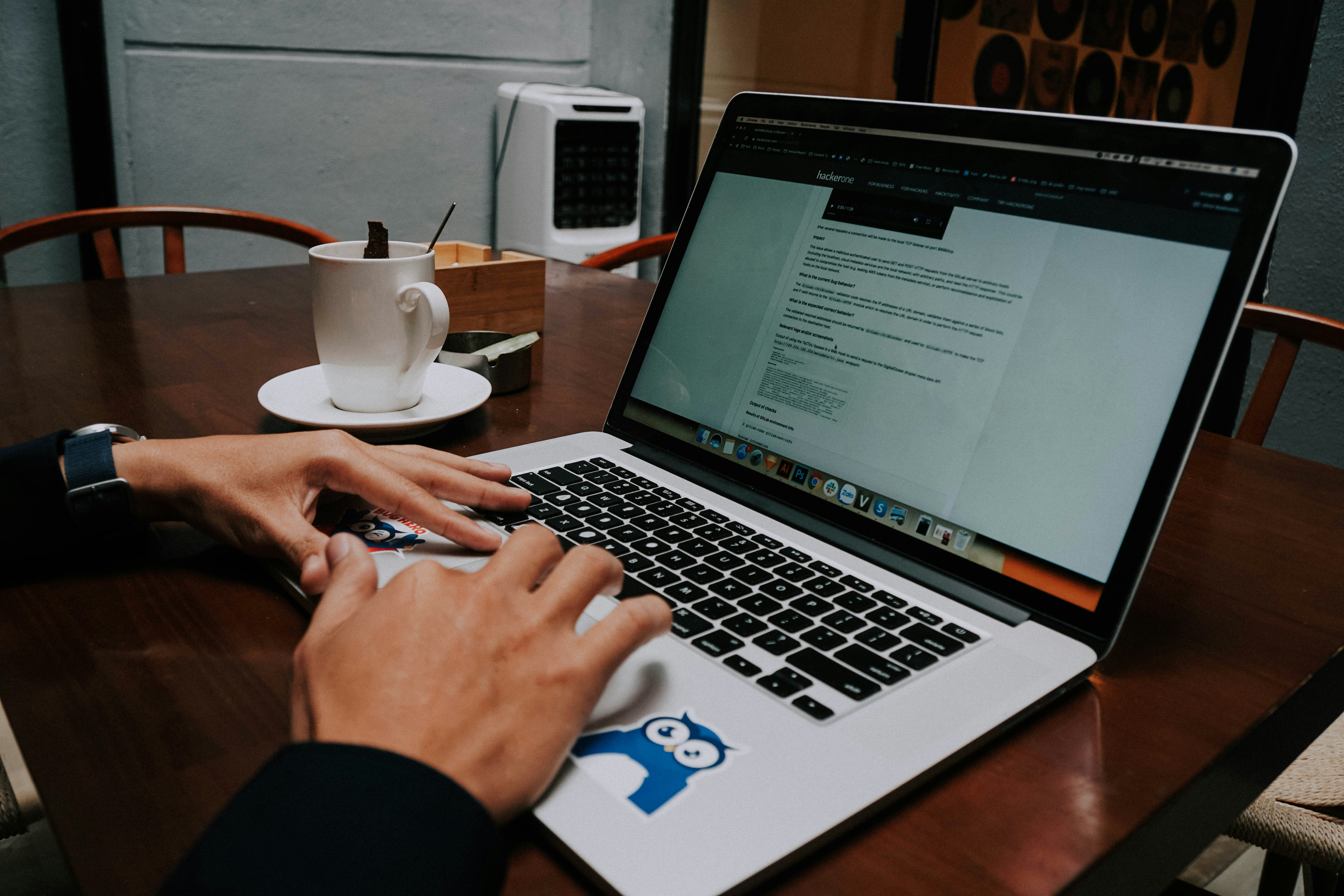 A person using a laptop on a wooden table